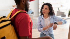 woman pointing at watch to late delivery driver