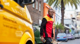 DHL employee walking past DHL marked van