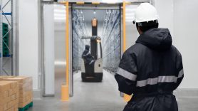 man watching man check warehouse on a forklift