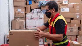 man in mask loading boxes