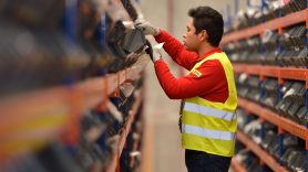 man sorting through small parcels in warehouse