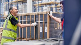 wrapped dhl parcel being pushed out of a warehouse by man 