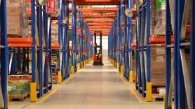 wrapped dhl parcel being pushed out of a warehouse by man 