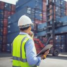 man with clipboard looking at containers