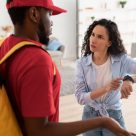 woman pointing at watch to late delivery driver