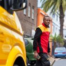 DHL employee walking past DHL marked van