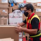 man in mask loading boxes