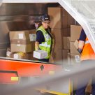 lady loading parcels in hard hat 