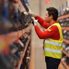 man sorting through small parcels in warehouse