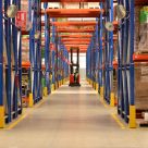 wrapped dhl parcel being pushed out of a warehouse by man 