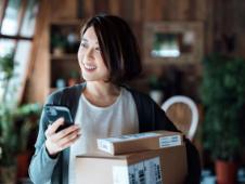 Young woman with cell phone and parcels