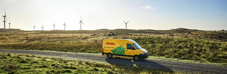 Van in a beautiful landscape with wind turbines in the background