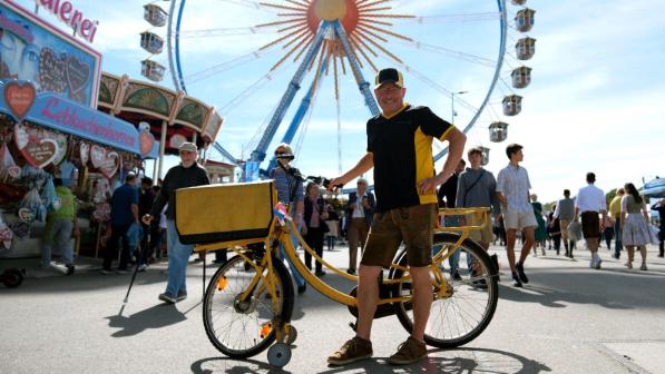 Wiesn-Zusteller Gerald Nadler mit dem Fahrrad vor dem Riesenrad