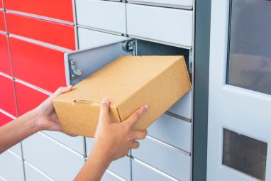 Woman pushes parcel into a Parcel Locker