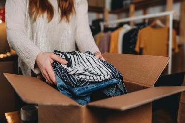 Woman packs old clothes in a box
