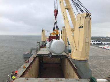 Wind turbine is loaded into the hold of a ship