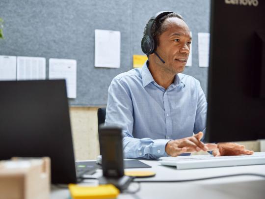 anställd-med-headset-arbetar-på-dator