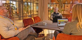 Three people sitting and working on their laptops