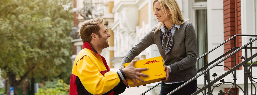 Mensajero de DHL entregando a una mujer un paquete