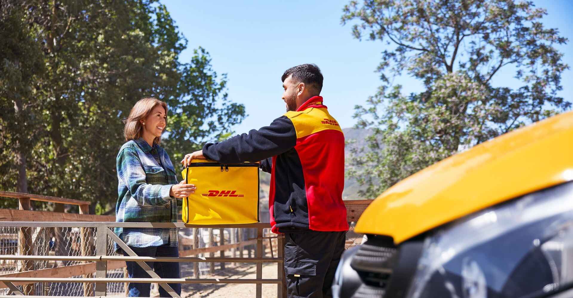 A male DHL employee collecting coffee bean exports with a specific reusable DHL cooling box from a new zealand coffee plantation