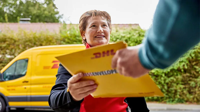 DHL delivery woman handing over a parcel to a man