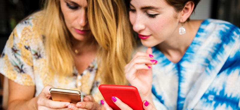 Two women looking at each other's phones