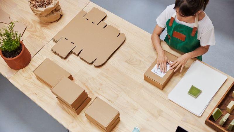 DHL employee packing parcel with sustainable packaging