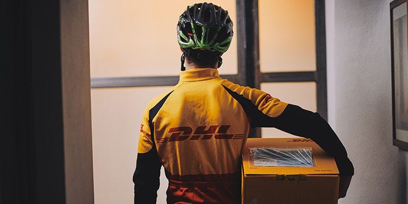 DHL courier holding a DHL parcel