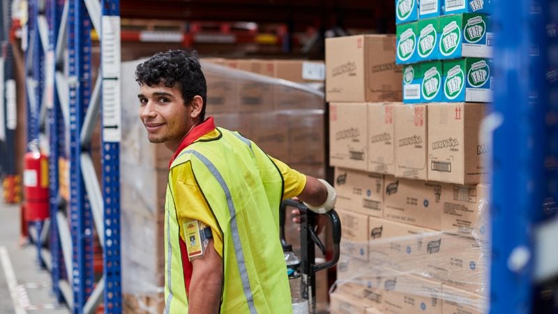 dhl express employee in india standing in front of parcels