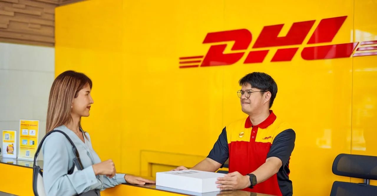 a woman dropping off a parcel at a dhl service point