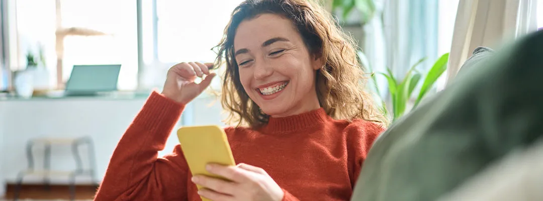 woman smiling at mobile phone