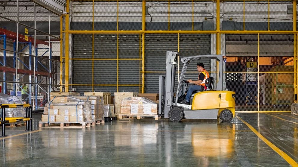 dhl express employee using a forklift to load a pallet box