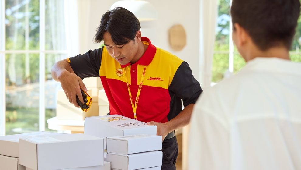 dhl employee is scanning parcels for pickup at a shop