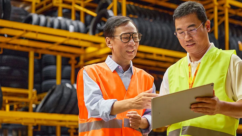 two Asian men looking at tablet screen