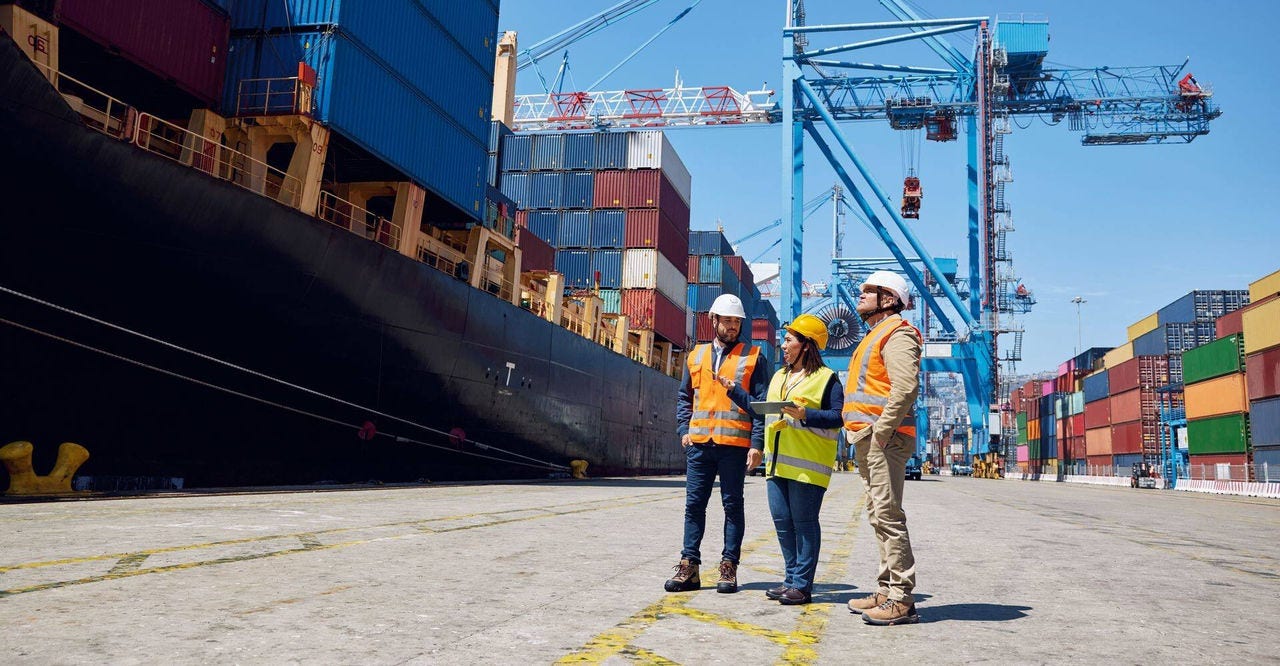 DHL employees at a large container shipyard overseeing shipments