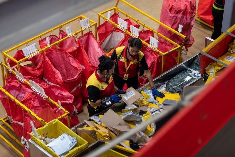 Two DHL Express employees scanning the care packages to be shipped to the UAE