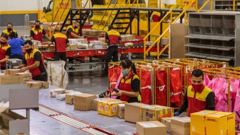 dhl employees sorting and tracking overseas parcels for shipment