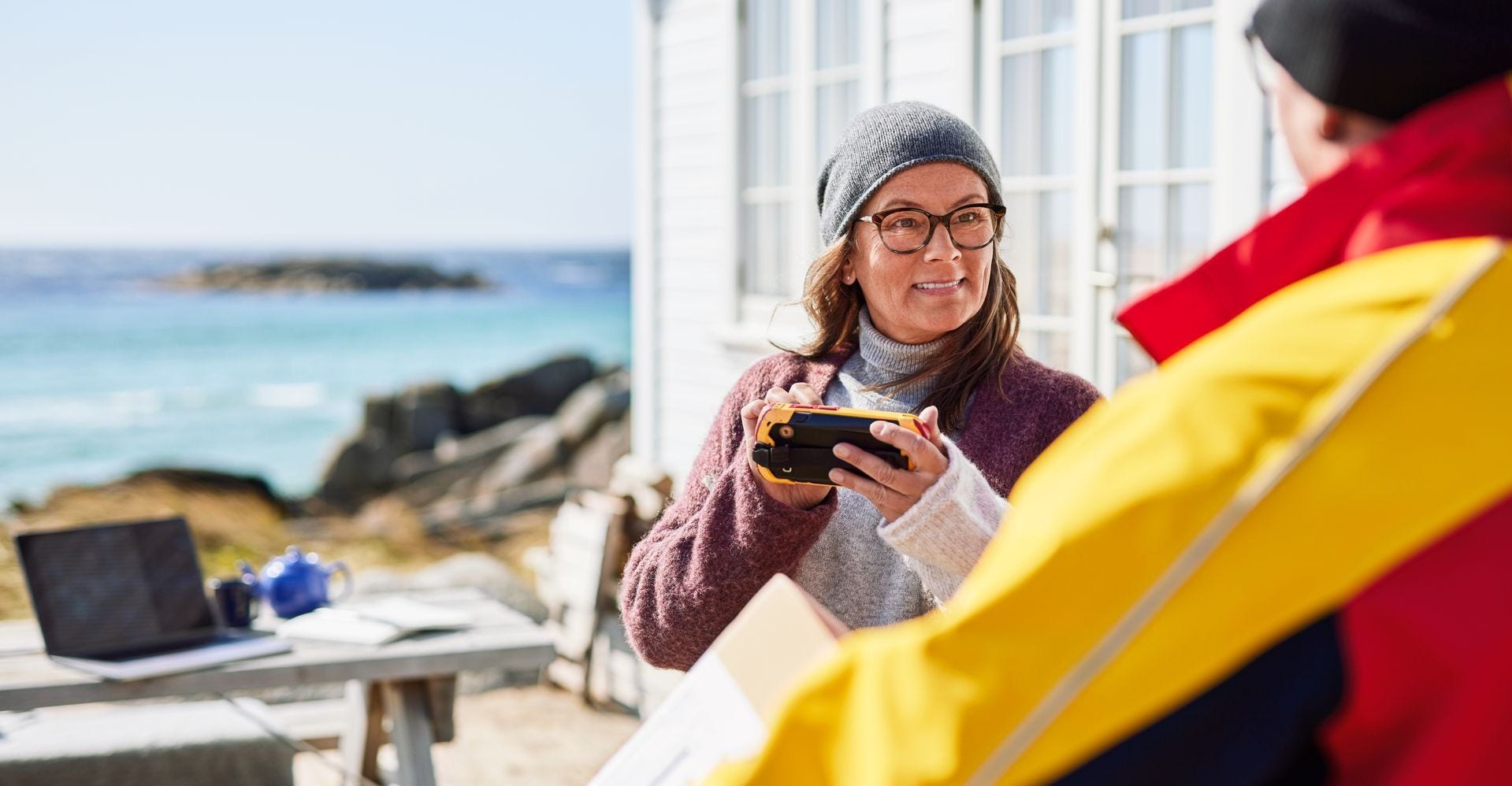 A female customer signing on the scanner while receiving her DHL package