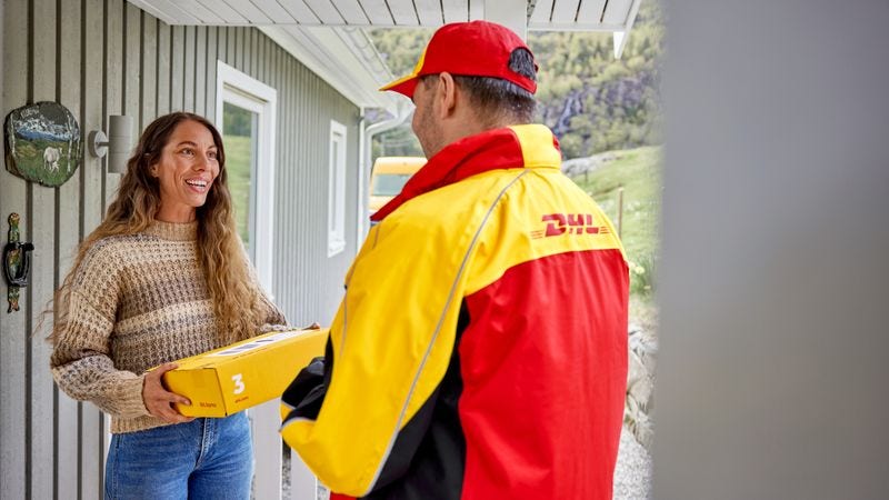 happy female customer receiving a parcel from DHL delivery man