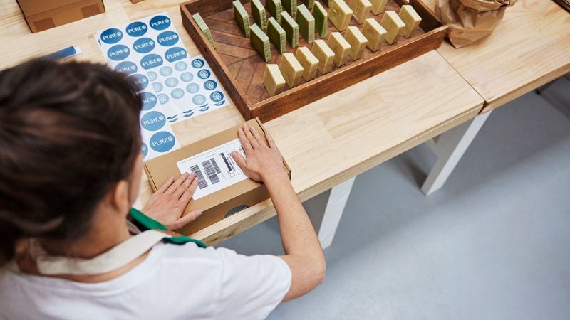 a woman preparing the packaging material for product shipment