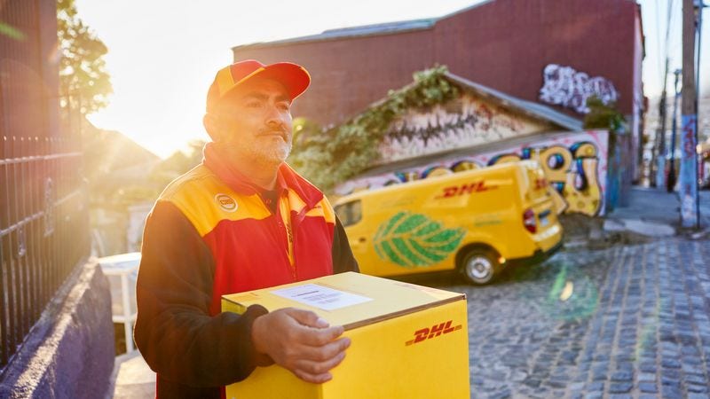 DHL employee carrying a yellow box from food importer