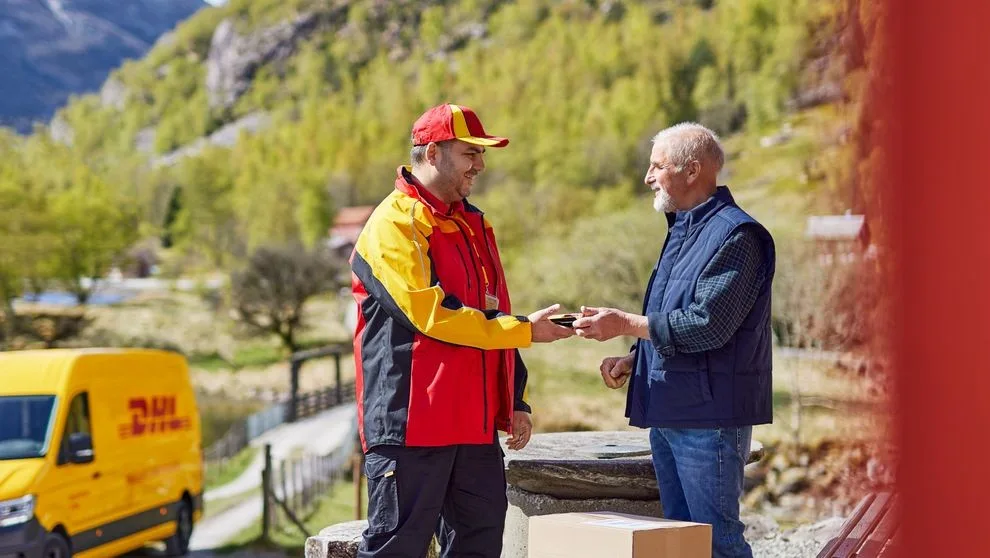 man handing New Zealand dairy exports to DHL employee