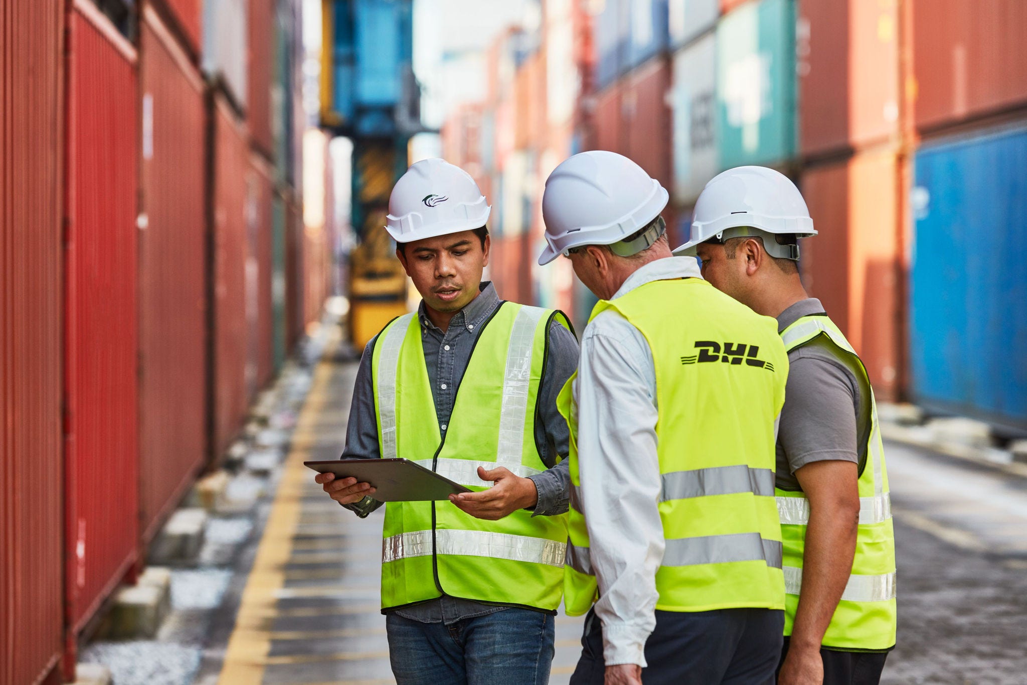 DHL employees surrounded by international shipping containers