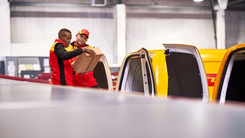 two dhl employees double checking parcel details before delivering