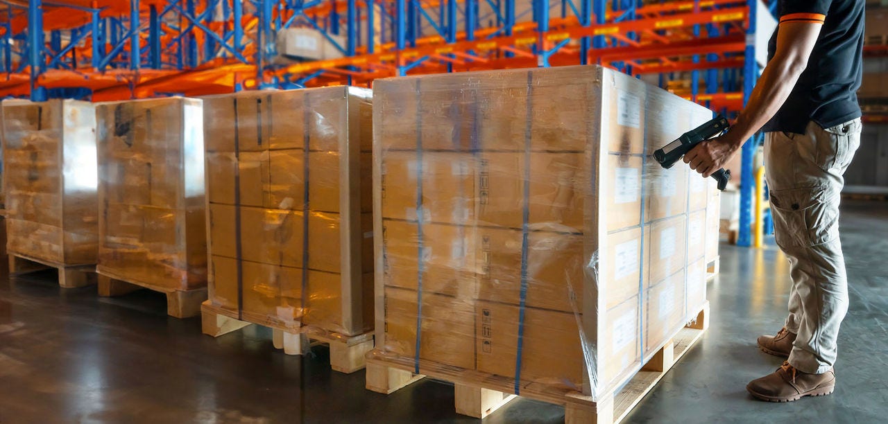 warehouse employee scanning boxes + Reducing International Shipping Costs