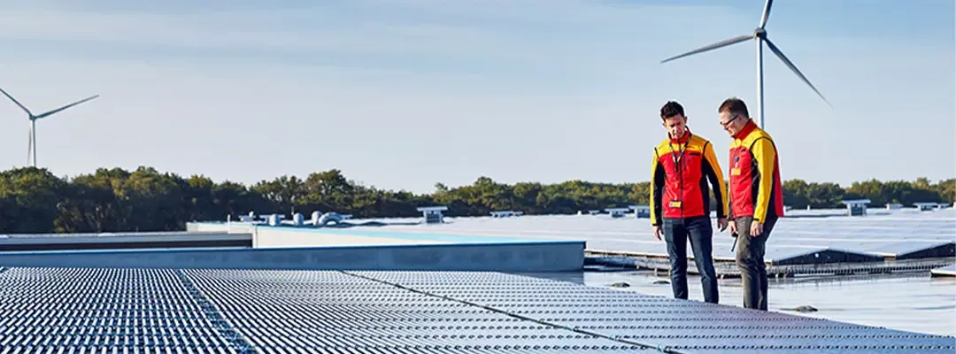 two DHL employees looking at solar panels