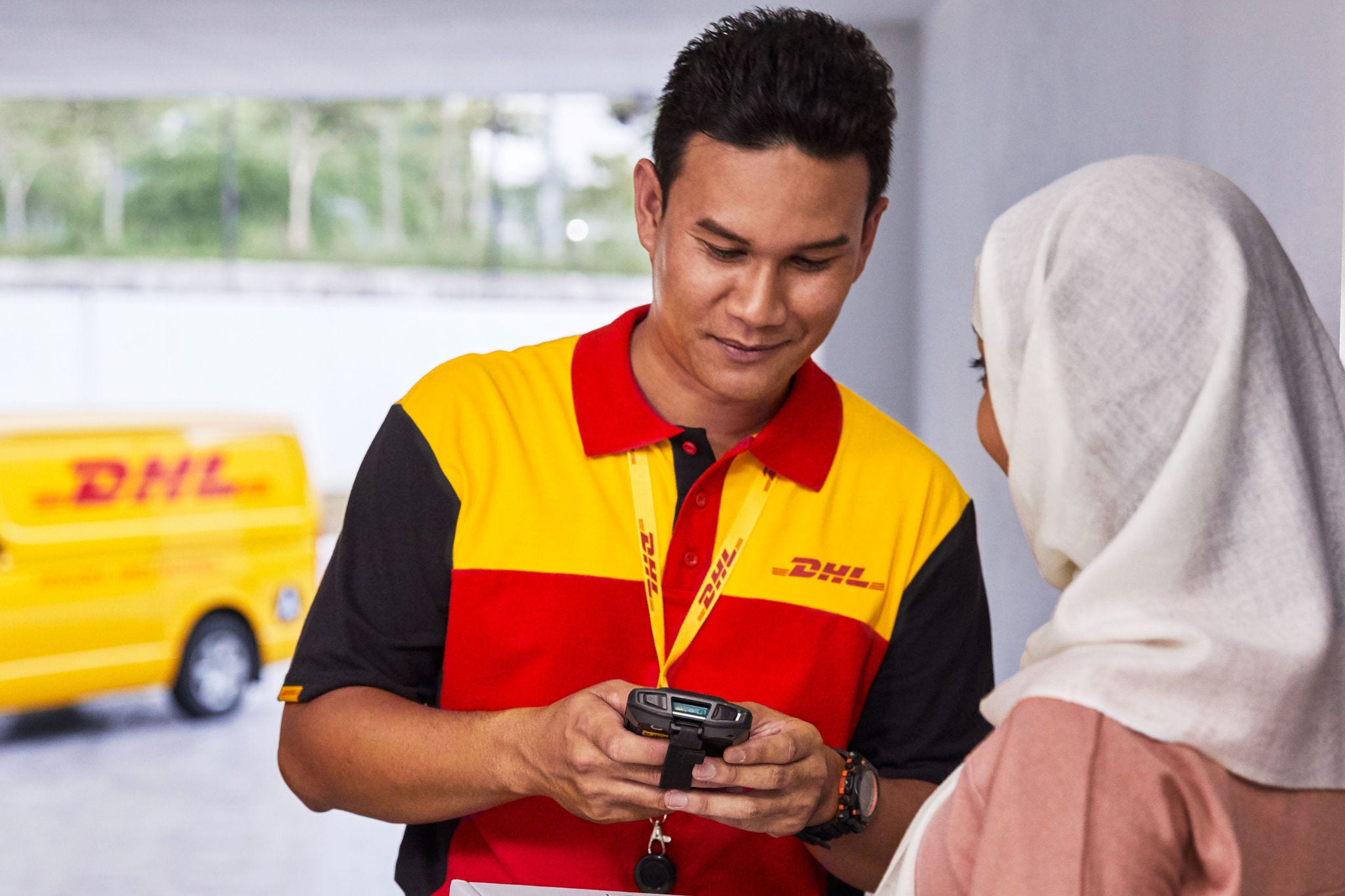 DHL delivery staff handing over an ordered package bought by a customer during festive season