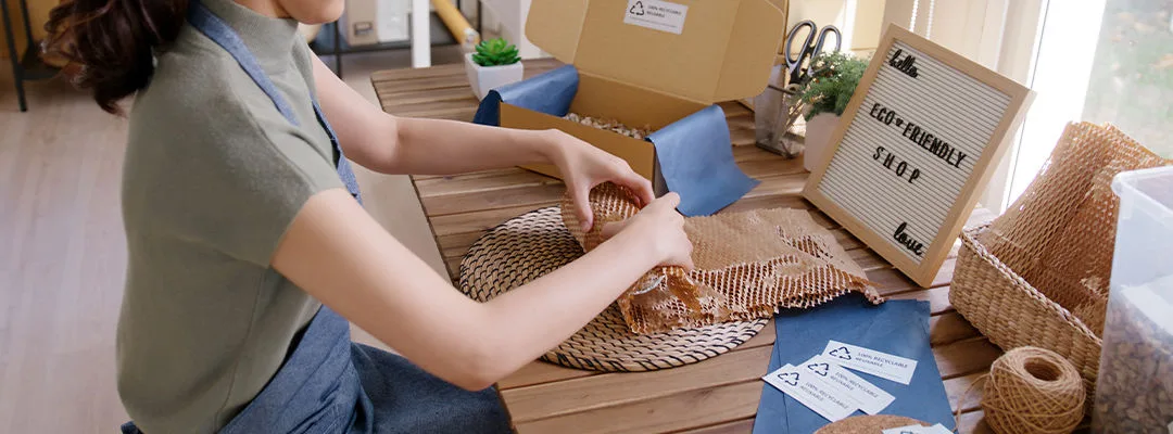 woman packing a parcel in brown packaging