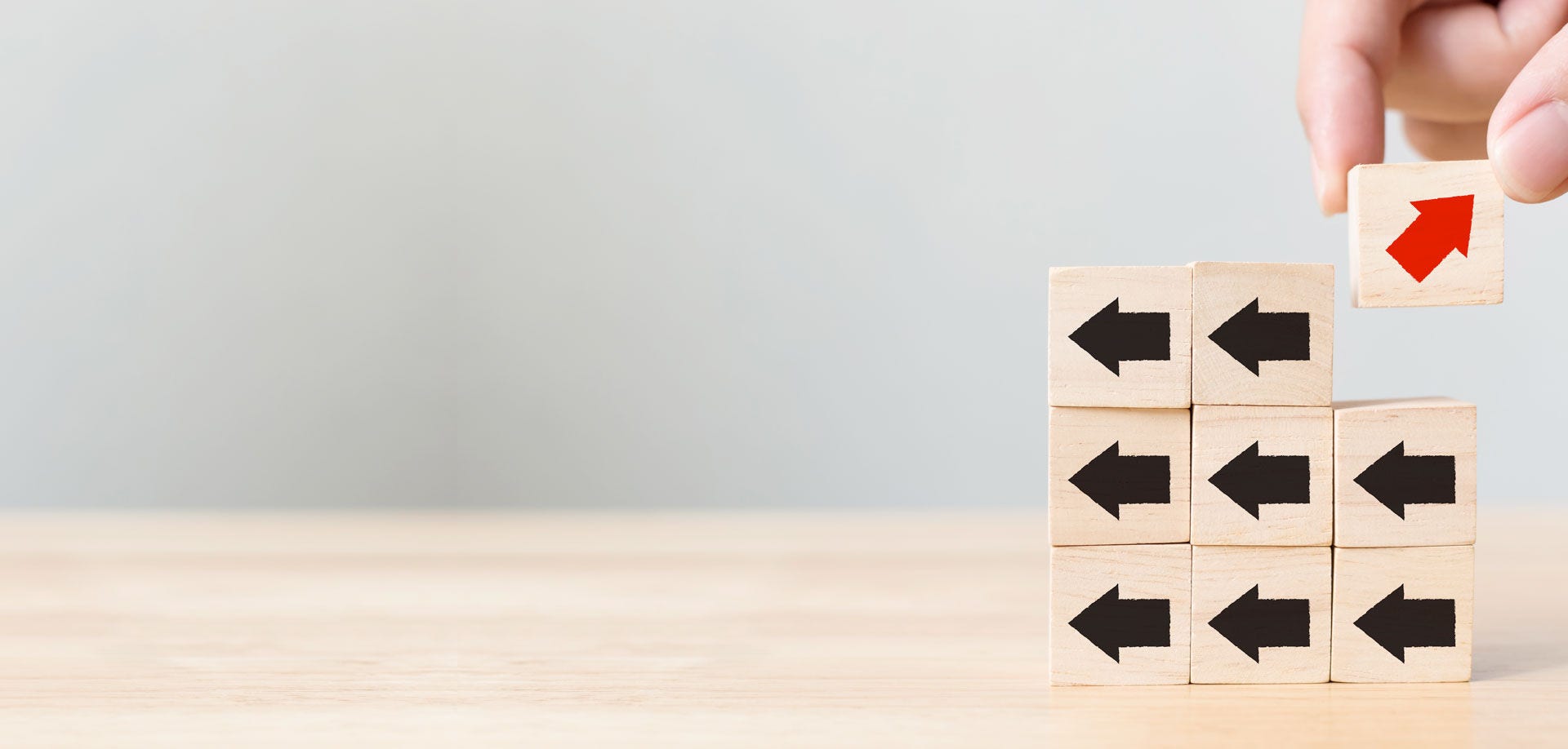 hand lifting a block with a red arrow