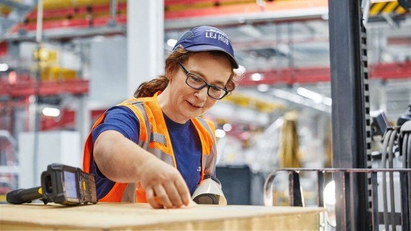 dhl express employee labelling a large package for overseas shipping